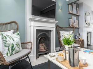 a living room with a fireplace and a table and chairs at Pass the Keys Luxury 2 Bedroom Townhouse in Central St Albans in St. Albans