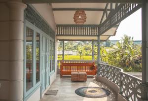 einen Balkon eines Hauses mit einer Bank darauf in der Unterkunft Villa Holy By The Villas 100 in Bogor