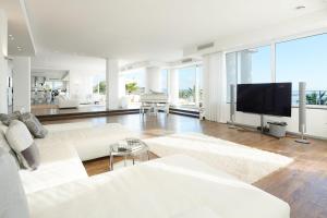 a living room with white furniture and a flat screen tv at Casa Minnustras - Santa Eulalia in Santa Eularia des Riu