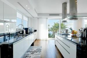 a kitchen with white counters and a large window at Casa Minnustras - Santa Eulalia in Santa Eularia des Riu