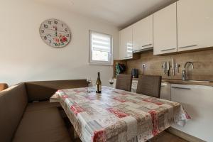 Una cocina con una mesa y un reloj en la pared. en Cozy Apartment Bovec - Happy Rentals, en Bovec