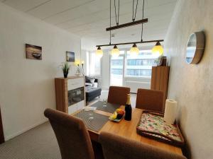 ein Wohnzimmer mit einem Esstisch und Stühlen in der Unterkunft Steinwarder 9 - Haus "Seeschwalbe" ST9 028 Steinwarder 9 in Heiligenhafen