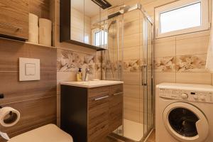 ein Badezimmer mit einer Waschmaschine und einem Waschbecken in der Unterkunft Cozy Apartment Bovec - Happy Rentals in Bovec