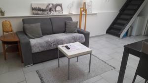 ein Wohnzimmer mit einem Sofa und einem Couchtisch in der Unterkunft Duplex Denim in Nîmes