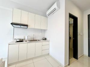 a kitchen with white cabinets and a sink at Gaia Residence, Gamuda Gardens Rawang by Sleepy Bear in Kuala Lumpur