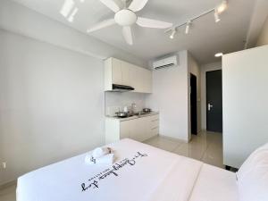 a bedroom with a white bed with a ceiling fan at Gaia Residence, Gamuda Gardens Rawang by Sleepy Bear in Kuala Lumpur