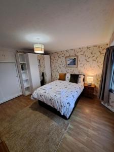 ein Schlafzimmer mit einem Bett in einem Zimmer in der Unterkunft Bungalow Three Bedroom The Park Onchan Isle of Man in Onchan