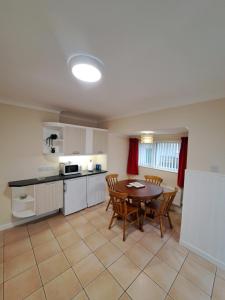 a kitchen and dining room with a table and chairs at Bungalow Three Bedroom The Park Onchan Isle of Man in Onchan