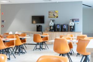 a classroom with tables and chairs and a tv at Akeah Verdi Budapest in Budapest