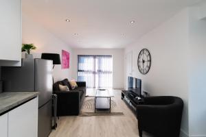 a living room with a couch and a clock on the wall at Spacious Luxury 2 Bedroom House in Derby