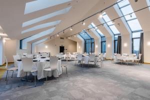 a banquet hall with white tables and chairs at Akeah Verdi Budapest in Budapest