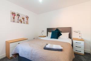 a bedroom with a bed and two night stands at Spacious Luxury 2 Bedroom House in Derby