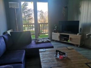 uma sala de estar com um sofá e uma televisão de ecrã plano em La casita em Tresserves