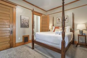 a bedroom with a four poster bed and a door at Crescent Estate - Golf Hot Tub BBQ Large Groups in Colorado Springs