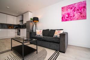 a living room with a couch and a table at Spacious Luxury 2 Bedroom House in Derby