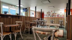 a restaurant with wooden tables and stools at Fasthotel Laval in Laval