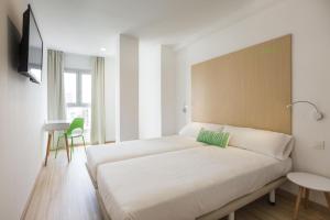 a bedroom with a large bed with a green pillow at SmartRoom Barcelona in Barcelona