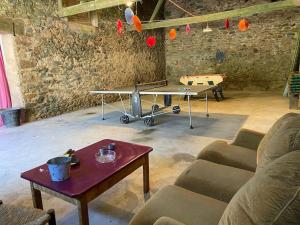 uma sala de estar com uma mesa de pingue-pongue e uma mesa de pingue-pongue em Domaine de Linars ☆ La Forge ☆ em Le Truel