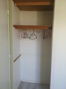 um armário com uma prateleira de madeira e cabides em La casita em Tresserves