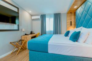 1 dormitorio con 1 cama grande y cabecero azul en Nobel Gallery Hotel en Belgrado