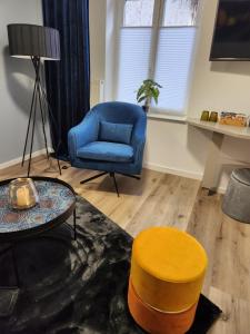 a living room with a blue chair and a table at Mastersuite in Bad Salzuflen