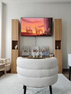 a living room with a white chair and a tv at Auberge at SMDC Hope Residences in Trece Martires