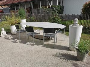 a table and chairs and a table and a statue at Komfortables Zimmer in ruhiger Wohnlage, inkl. Tax in Dornbirn
