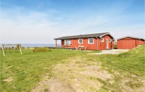 una casa roja en un campo con parque infantil en Amazing Home In Faaborg With 4 Bedrooms, Sauna And Wifi, en Bøjden