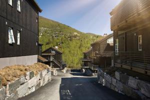 a street between two buildings with a mountain at Stranda Fjellgrend - with jacuzzi & 3 bedrooms in Stranda