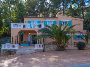 ein Haus mit einer Palme davor in der Unterkunft Casa Blanca Casa con piscina en Esporles in Esporles
