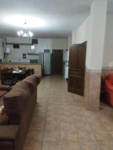 ein Wohnzimmer mit einem Sofa und einer Küche in der Unterkunft Casa Tita Carmen in Córdoba