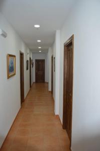 einen Flur mit weißen Wänden und Holztüren in der Unterkunft Casa Tita Carmen in Córdoba