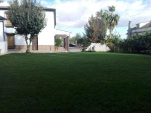 einen Garten mit grünem Rasen vor einem Haus in der Unterkunft Casa Tita Carmen in Córdoba