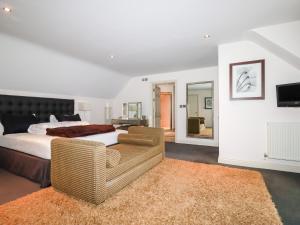 1 dormitorio con cama, sofá y TV en Lodge 22 Cherry en Wadebridge
