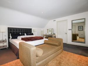 1 dormitorio con cama, sofá y espejo en Lodge 22 Cherry en Wadebridge