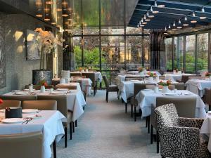 a restaurant with white tables and chairs and windows at Hotel Lindauer Hof in Lindau