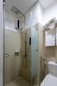 a shower with a glass door in a bathroom at Lush Residences Makati in Manila