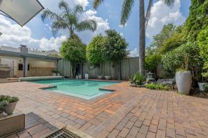 a swimming pool in a backyard with a fence at Roslin Apartments in Johannesburg