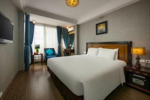 ein Schlafzimmer mit einem großen weißen Bett und einem Fenster in der Unterkunft Classic Street Hotel in Hanoi