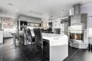 a kitchen with a table and chairs and a fireplace at Luleå Riverside Villa: Peace & Luxe in Gammelstaden