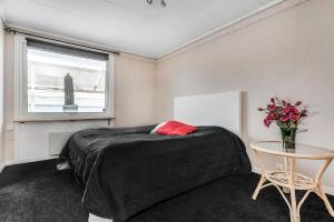 Schlafzimmer mit einem Bett, einem Tisch und einem Fenster in der Unterkunft Luleå Riverside Villa: Peace & Luxe in Gammelstaden