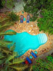 an overhead view of a swimming pool with umbrellas at Demani Lodge Zanzibar in Paje