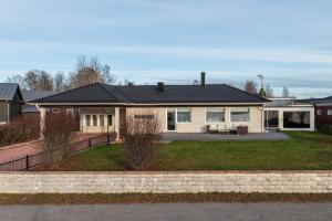 a white house with a black roof at Luleå Riverside Villa: Peace & Luxe in Gammelstaden
