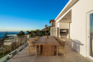 a dining table on a balcony with a view of the ocean at View16 in Cape Town