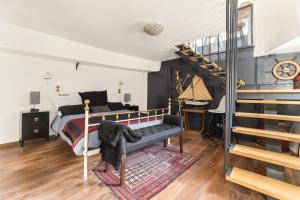 - une chambre avec un lit et un escalier en colimaçon dans l'établissement Péniche, à Issy-les-Moulineaux