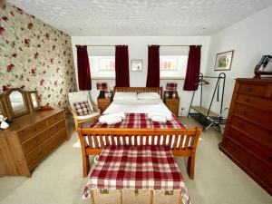 a bedroom with a bed with a red and white blanket at Comfortable 4 bed Home, Valhalla, Helmsdale in Helmsdale