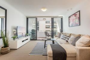 a living room with a couch and a tv at MadeComfy Executive & Stylish Inner-City Apartment in Sydney