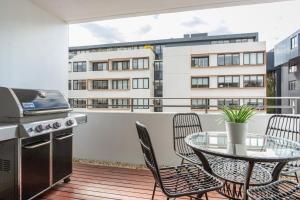 a balcony with a table and chairs and a grill at MadeComfy Executive & Stylish Inner-City Apartment in Sydney