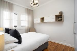 Habitación blanca con cama y ventana en Coastal Living Just Metres From Coogee Beach en Sídney