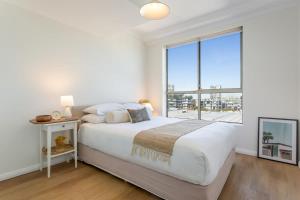 um quarto com uma cama grande e uma janela grande em Bright and Modern Apartment in Amazing Location em Sydney